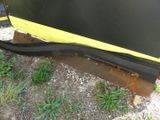 a black and yellow boat sitting in the grass