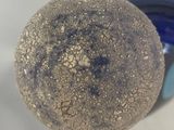 a close up of a ball of dirt on a white surface