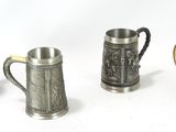 Quatre types différents d'objets en étain sont alignés sur une surface blanche