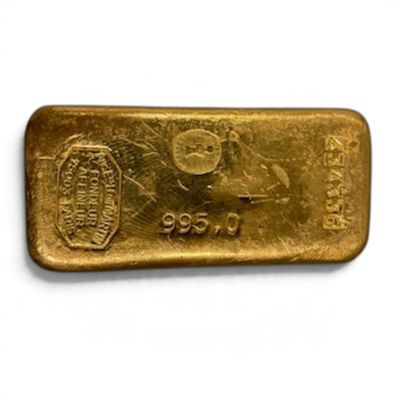 un lingot d'or posé sur une surface blanche, sur fond blanc