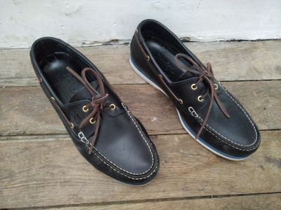 une paire de chaussures bateau en cuir pour homme posée sur un parquet