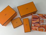 quatre boîtes orange et marron sont posées sur une surface blanche