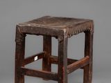 an old wooden stool with a wooden seat on a gray background