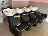 une rangée de lavabos dans des toilettes publiques aux murs roses