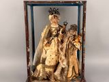 statue représentant un groupe de personnes, exposée dans une vitrine sur fond blanc