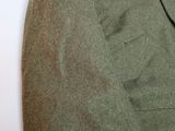 a green jacket sitting on top of a white table