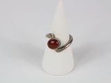 silver ring with a red stone on it on a white cone