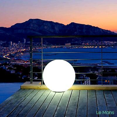 a white ball sitting on a wooden deck overlooking a city