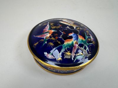 une boîte bleue et dorée sur laquelle sont peints des oiseaux