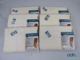 six white towels are stacked on top of each other on a table