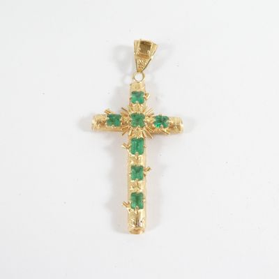 an image of a gold cross with green stones on a white background