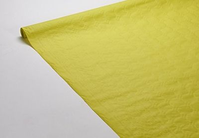 un gros plan sur un morceau de tissu jaune posé sur une surface blanche