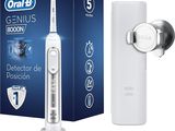une photo d'une brosse à dents électrique blanche posée à côté d'un tube de dentifrice