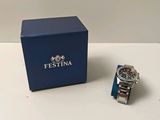 an image of a watch sitting next to a blue box on a table