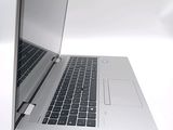 a silver laptop with a black keyboard on a white surface