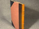 an orange and black book sitting on top of a gray surface