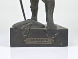 statue of a man with a sword and a hat on a base