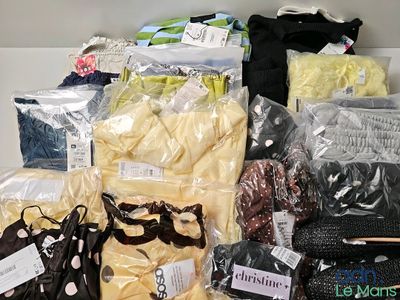 de nombreux sacs contenant des vêtements et d'autres objets posés sur une table
