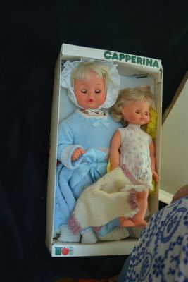 a box with two dolls in it on a table