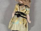 a small doll with blonde hair and a dress on