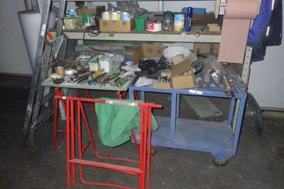 un établi dans un garage, encombré de toutes sortes d'objets