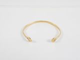 un bracelet manchette en or orné de deux petites perles
