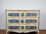 une photo d'une commode bleue et blanche posée sur un parquet