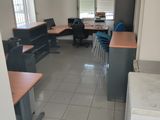 une photo d'un bureau vide avec des bureaux et des chaises