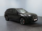a black car parked in a room with a white wall