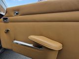 a tan car door handle with a black handle