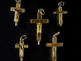 four gold crosses are shown on a black surface