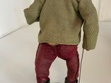 figurine of a man with a hat, sweater and boots holding a cane