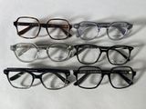 quatre paires de lunettes sont alignées sur une surface blanche