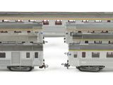 three silver train cars are stacked on top of each other