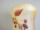 un vase avec un tableau posé sur une table