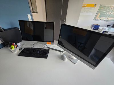 un bureau équipé de deux écrans et d'un clavier