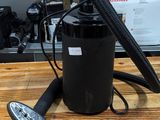 a black canister with a remote on a wooden table