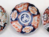 three plates with different designs on them sitting on a white surface