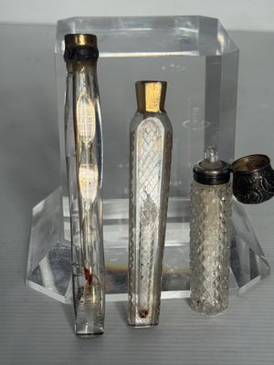 deux bouteilles en verre et un vase en argent posés sur une table