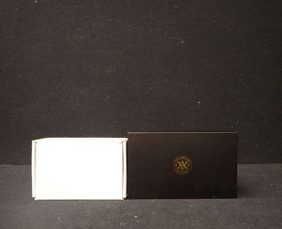 une boîte noire et blanche et une boîte blanche posées sur une table
