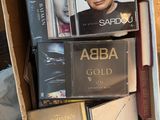 une boîte remplie de DVD et de CD posée sur un lit