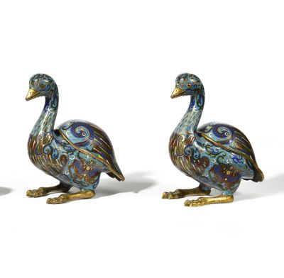 two blue and gold ducks sitting next to each other on a white surface