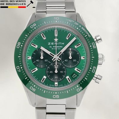 a close up of a watch with a green face