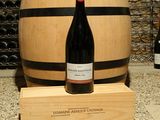 une bouteille de vin posée à côté d'un tonneau de vin