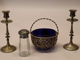 trois bougies et un panier posés sur une table, à côté d'une salière