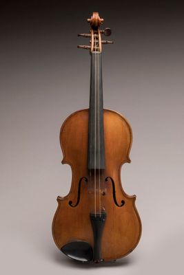 un vieux violon posé sur une surface blanche