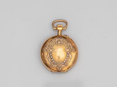 an antique gold pocket watch on a white surface with a chain