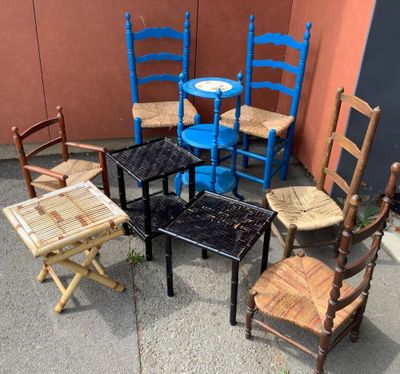 Plusieurs chaises et une table sont disposées en cercle sur le trottoir.