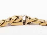 a close up of a gold bracelet with a diamond on it