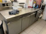 stainless steel counter top in a commercial kitchen with a trash can